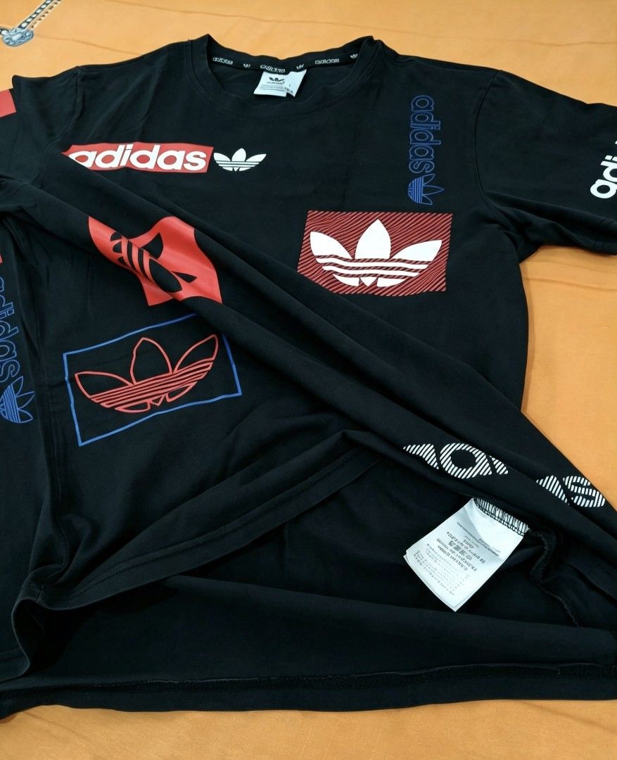 Adidas Black Graphic T-Shirt (Category: Tshirts & Polo Shirts ) located in Manila. Submitted by noblehorse-dccec0 (Listing ID 1464072626, Image 2). Description: - Classic black Adidas t-shirt - Features multiple graphic logos in red, blue, and white - Iconic Adidas branding - Short sleeves dimes: 20x25.
