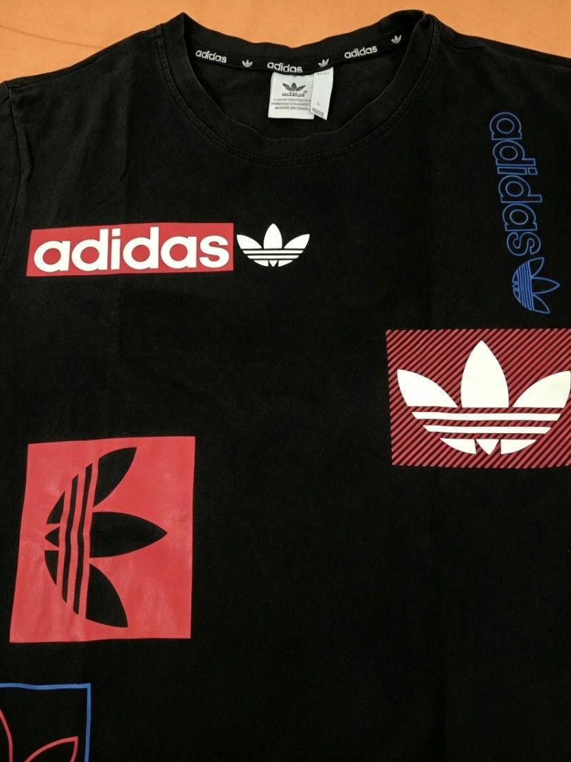 Adidas Black Graphic T-Shirt (Category: Tshirts & Polo Shirts ) located in Manila. Submitted by noblehorse-dccec0 (Listing ID 1464072626, Image 3). Description: - Classic black Adidas t-shirt - Features multiple graphic logos in red, blue, and white - Iconic Adidas branding - Short sleeves dimes: 20x25.