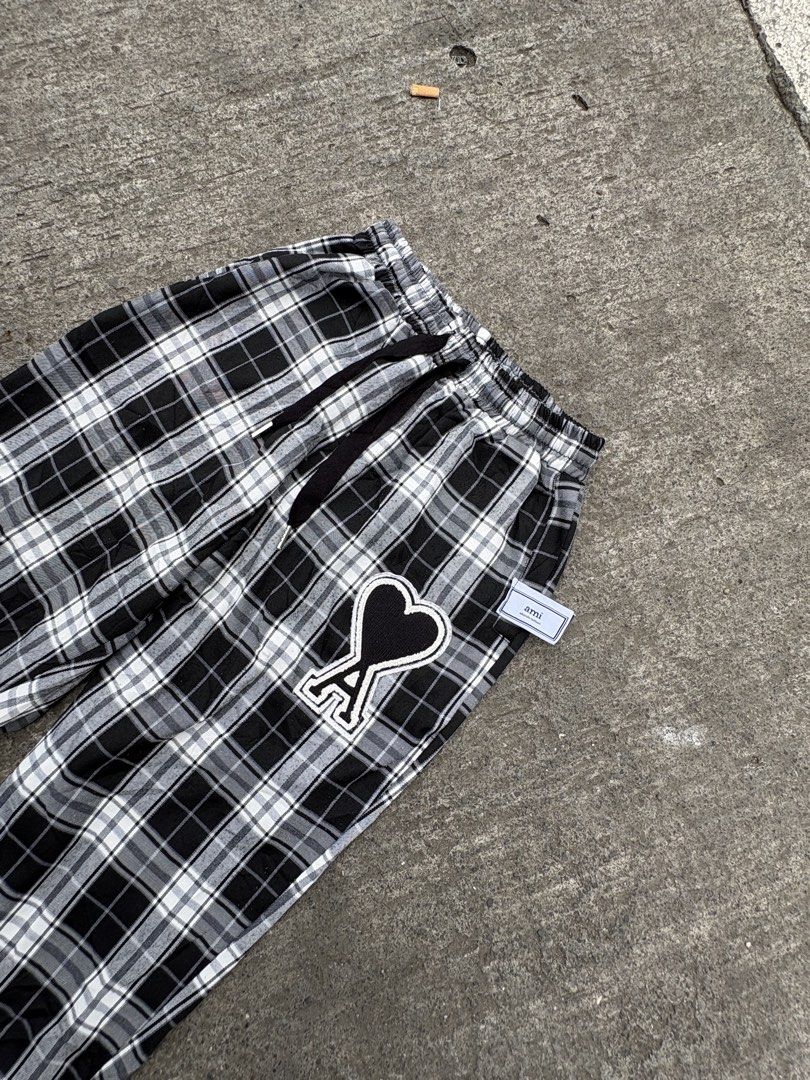 AMI Alexandre Mattiussi Plaid Pants (Category: Trousers) located in Iligan City. Submitted by seddicmoti2002 (Listing ID 1463981786, Image 2). Description: - AMI black and white plaid pants - Features iconic Ami de Coeur logo patch on left leg - Elastic waistband with adjustable drawstring - Cuffed ankles for a stylish finish - Comfortable and perfect for casual outfits.