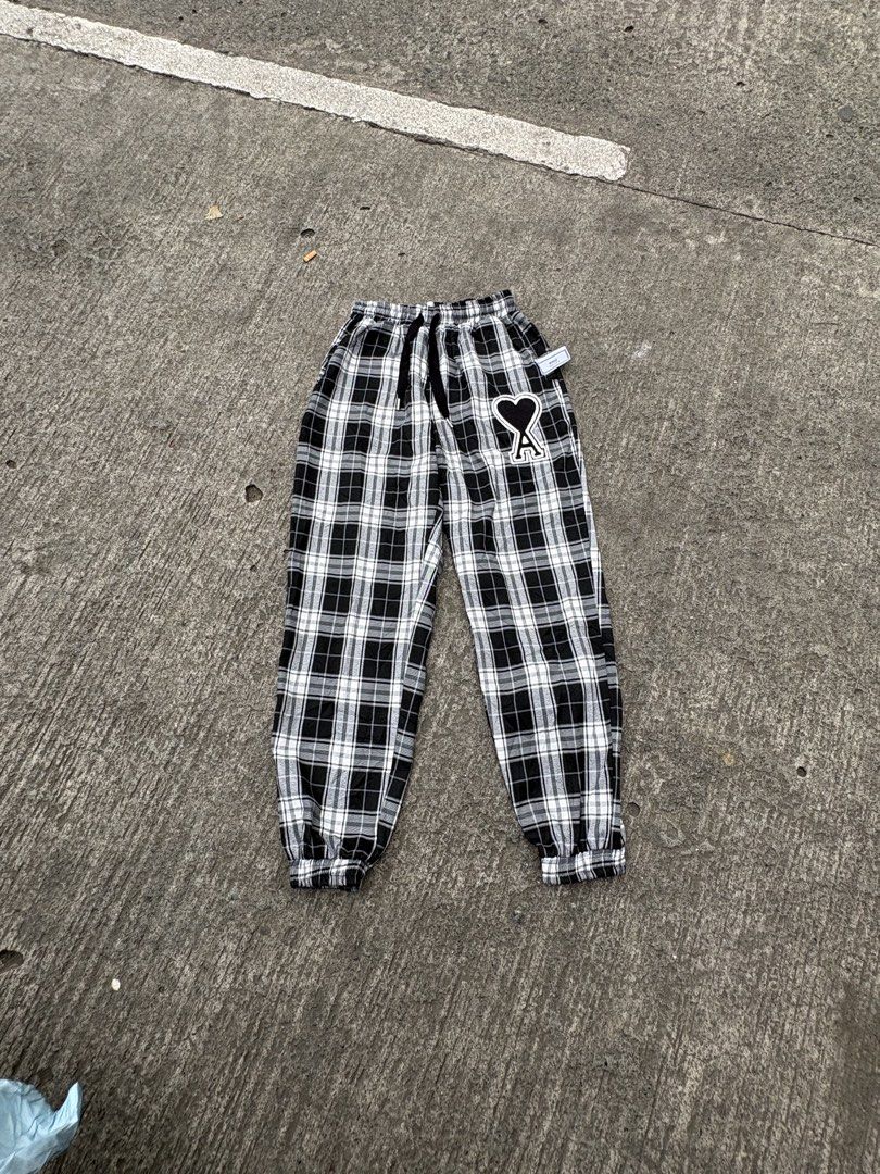 AMI Alexandre Mattiussi Plaid Pants (Category: Trousers) located in Iligan City. Submitted by seddicmoti2002 (Listing ID 1463981786, Image 1). Description: - AMI black and white plaid pants - Features iconic Ami de Coeur logo patch on left leg - Elastic waistband with adjustable drawstring - Cuffed ankles for a stylish finish - Comfortable and perfect for casual outfits.
