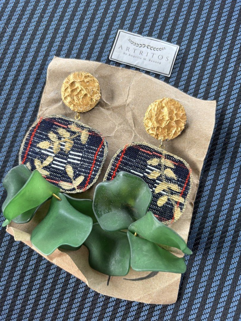 ARTRIOS Gold & Fabric Statement Earrings (Local & Handmade) (Category: Earrings) located in Baguio. Submitted by pinkynj (Listing ID 1464000082, Image 2). Description: - Unique ARTRIOS earrings by designer Angelie M. Banaag. - Features elegant gold textured studs. - Fabric panels with a dark background, detailed with gold and red threads. - Dangling green petal-like accents add a unique touch. - A stunning statement piece to elevate any outfit. -