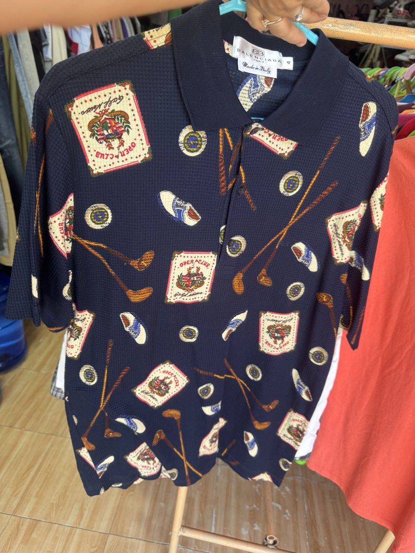 Balenciaga 100% Original (Category: Luxury Apparel) located in Manila. Submitted by wildbear.e10374 (Listing ID 1463958602, Image 2). Description: - Navy blue Balenciaga Paris polo shirt - Features a fun all-over print with golf motifs, clubs, and 'Open Club' graphics - Short sleeves and collared neckline - Made in Italy - Ideal for Occasion or daily Balenciaga collectors.