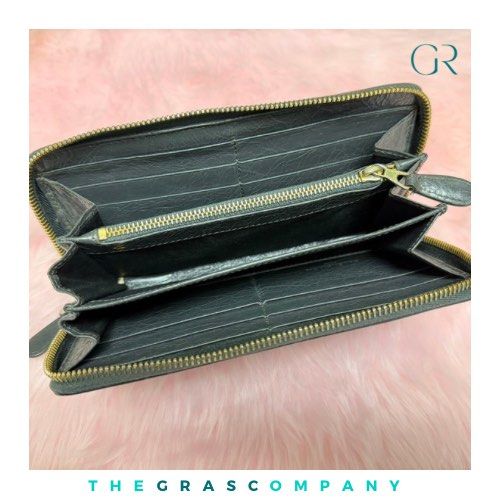 Balenciaga Leather Zip Around Wallet (Category: Luxury Bags & Wallets) located in Quezon City. Submitted by thegrasc.company (Listing ID 1464120909, Image 3). Description: - Authentic gray leather Balenciaga wallet - Secure zip-around closure - Multiple interior card slots and compartments for organization - Minor signs of wear on exterior leather and hardware - Interior is clean and well-maintained - Perfect for keeping your essentials tidy.