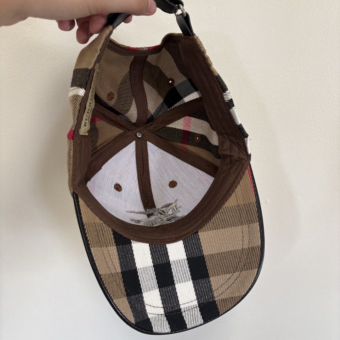 BB Nova Check Baseball Cap (Category: Caps & Hats) located in Imus. Submitted by reloved.nd (Listing ID 1464071918, Image 3). Description: - Iconic Burberry Nova Check pattern - Embroidered Burberry knight emblem on front - Adjustable strap with leather detailing at the back - Versatile accessory for any outfit - Note: Shows some signs of wear on the inner band.