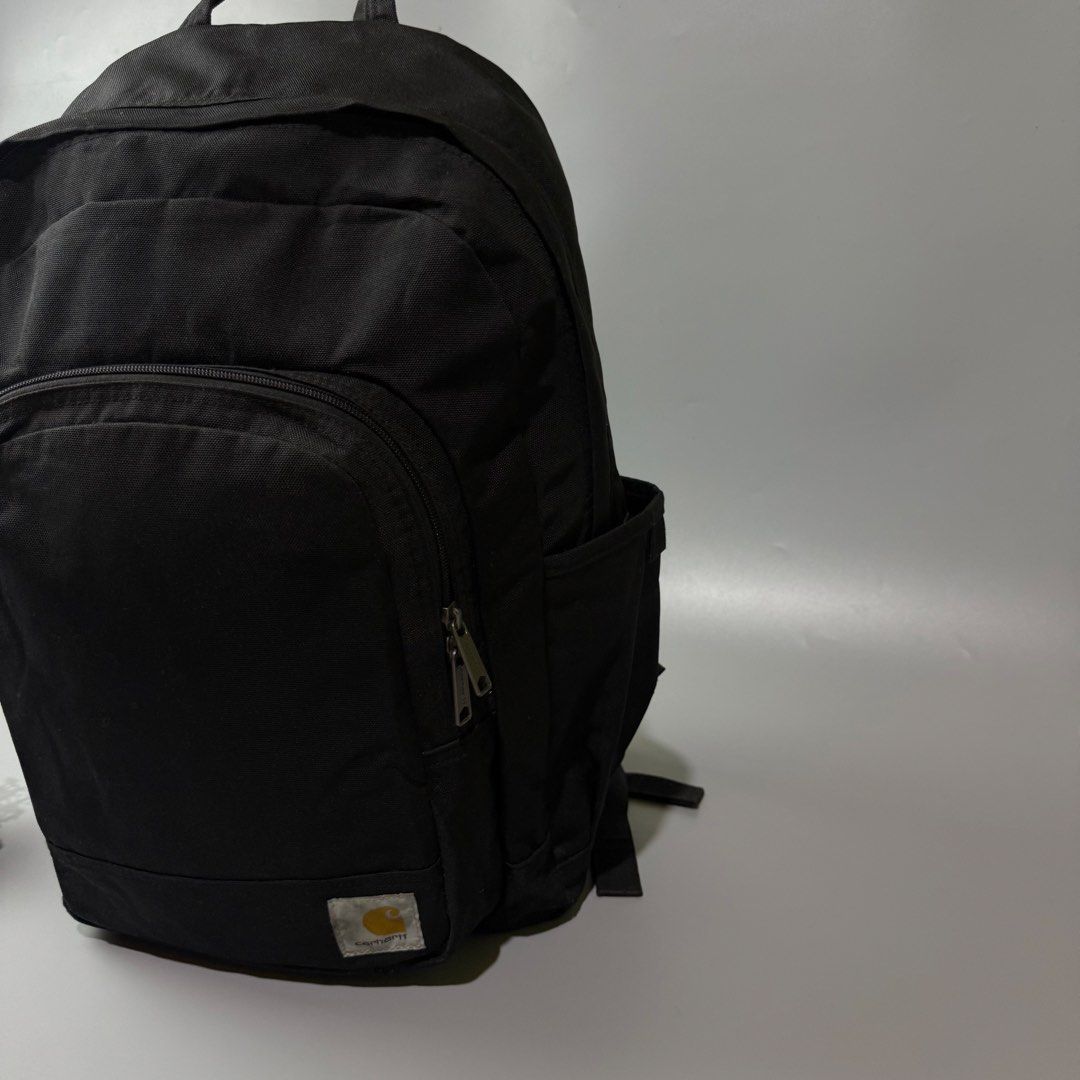 Black Carhartt Backpack (Category: Backpacks) located in Bago City. Submitted by g___shop (Listing ID 1464047129, Image 2). Description: - Classic black Carhartt backpack - Durable canvas material - Spacious main compartment - Front zip pocket - Side pockets for extra storage - Ideal for school or everyday use - Ready for a new owner.