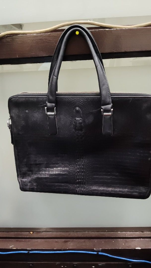 Black Crocodile Embossed Leather Briefcase Bag (Category: Briefcases) located in Paranaque City. Submitted by joycelyn10 (Listing ID 1463947816, Image 2). Description: - Genuine black leather briefcase - Crocodile embossed texture - Main zippered compartment - Front zippered pocket - 'FLOUAC KENTO' logo zipper pull - Fabric interior lining - Interior leather tag with embossed text - Sturdy handles - Ideal for work or travel.