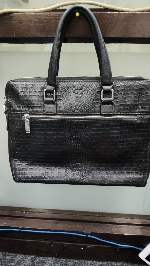 Black Crocodile Embossed Leather Briefcase Bag (Category: Briefcases) located in Paranaque City. Submitted by joycelyn10 (Listing ID 1463947816, Image 1). Description: - Genuine black leather briefcase - Crocodile embossed texture - Main zippered compartment - Front zippered pocket - 'FLOUAC KENTO' logo zipper pull - Fabric interior lining - Interior leather tag with embossed text - Sturdy handles - Ideal for work or travel.