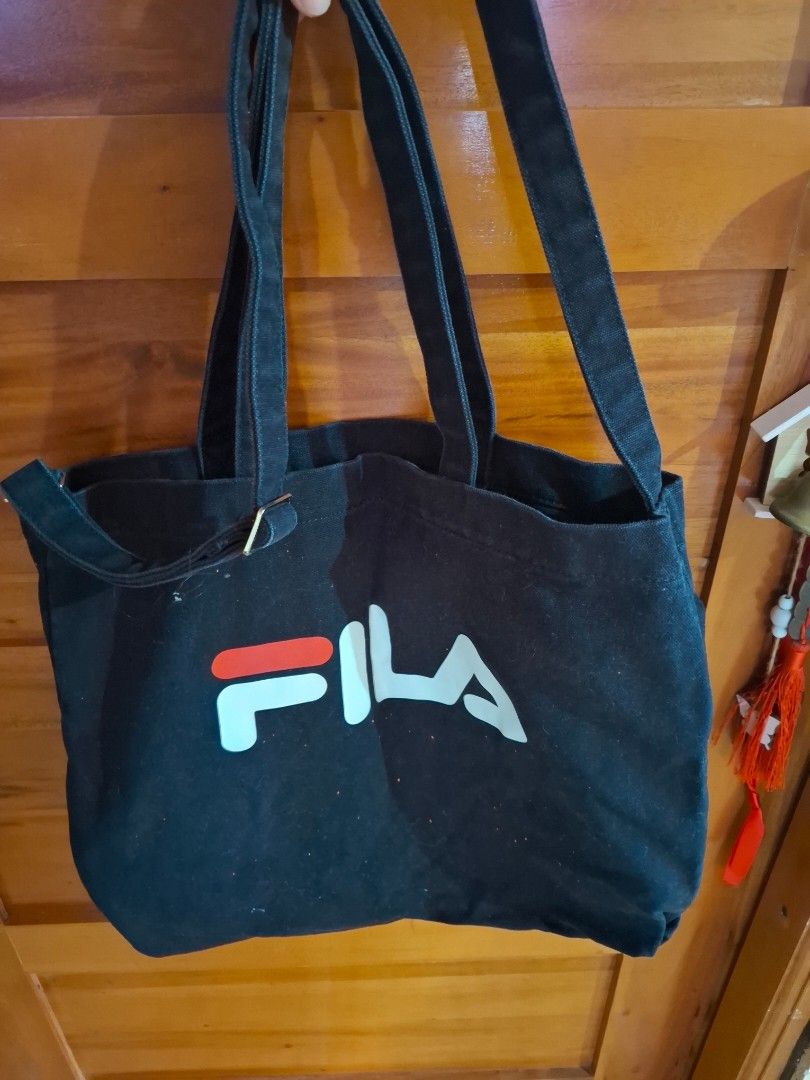 Black Fila Tote Bag (Category: Tote Bags) located in Muntinlupa City. Submitted by googoosh_collection (Listing ID 1463971957, Image 2). Description: - Classic black Fila tote bag - Features iconic Fila logo on the front - Made from durable canvas material - Two comfortable shoulder straps - Ideal for everyday use, shopping, or carrying essentials - Simple and stylish design *RFS: Decluttering (Need lang po labhan na stock sa package from abroad.