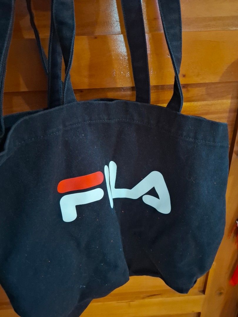 Black Fila Tote Bag (Category: Tote Bags) located in Muntinlupa City. Submitted by googoosh_collection (Listing ID 1463971957, Image 1). Description: - Classic black Fila tote bag - Features iconic Fila logo on the front - Made from durable canvas material - Two comfortable shoulder straps - Ideal for everyday use, shopping, or carrying essentials - Simple and stylish design *RFS: Decluttering (Need lang po labhan na stock sa package from abroad.