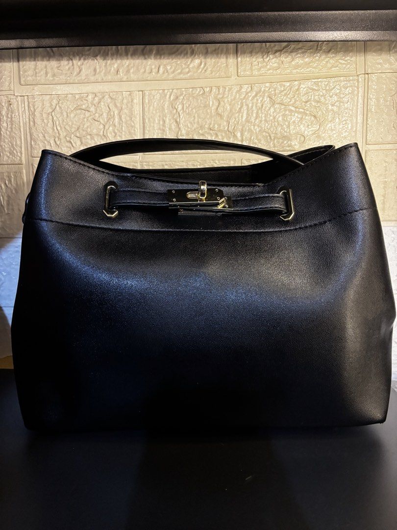 Black Handbag with Gold Clasp (Category: Tote Bags) located in Caloocan City. Submitted by _avionlineshop24 (Listing ID 1464137227, Image 1). Description: - Classic black handbag - Secure gold clasp closure - Faux leather material - Sturdy top handle - Versatile for everyday or dressing up - Simple and chic design.
