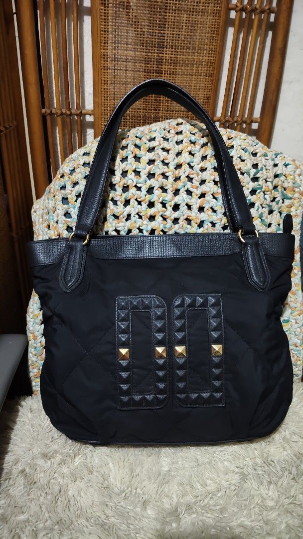 Daks...Black Quilted Tote Bag with Gold Studs (Category: Tote Bags) located in Cebu City. Submitted by lumaynojes00490 (Listing ID 1463960765, Image 3). Description: - Stylish black quilted tote bag - combi of nylon & leather trim and handles - Decorative gold pyramid studs on front panels - Structured, flat base for stability - Spacious interior, ideal for everyday essentials - A practical and fashionable accessory.