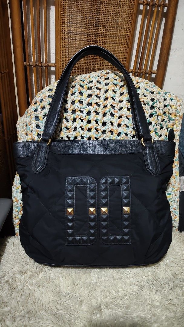 Daks...Black Quilted Tote Bag with Gold Studs (Category: Tote Bags) located in Cebu City. Submitted by lumaynojes00490 (Listing ID 1463960765, Image 2). Description: - Stylish black quilted tote bag - combi of nylon & leather trim and handles - Decorative gold pyramid studs on front panels - Structured, flat base for stability - Spacious interior, ideal for everyday essentials - A practical and fashionable accessory.