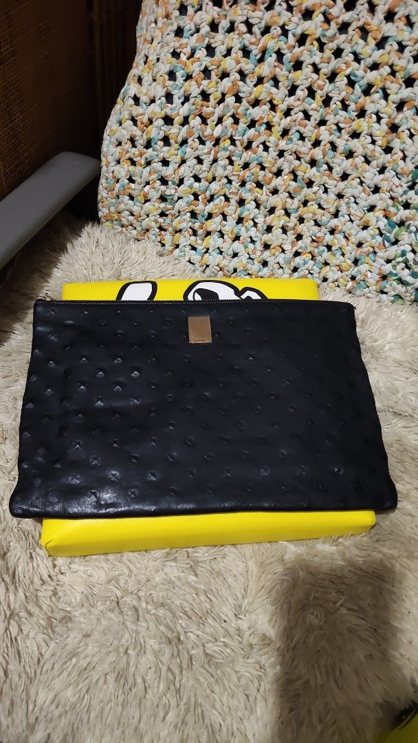 Couronne...Black Textured Clutch Bag with Gold Accent (Category: Clutches) located in Cebu City. Submitted by lumaynojes00490 (Listing ID 1463965514, Image 1). Description: - Elegant black clutch bag - Textured finish for a sophisticated look - Small gold plate detail on the front - Secure zipper closure - Ideal for evenings out or carrying essentials - Dimensions: Approximately 13 inches wide x 9 inches tall.