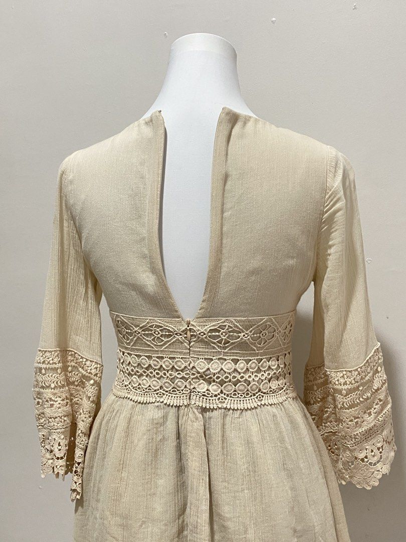 Boho Lace Mini Dress (Category: Dresses) located in Manila. Submitted by toastybread (Listing ID 1464024045, Image 2). Description: - Cream/beige mini dress - Intricate lace detailing - Deep V-neck with gold bead accents - Bell sleeves - Cinched waist with crochet trim - Back zipper closure - Perfect for a bohemian or festival look.