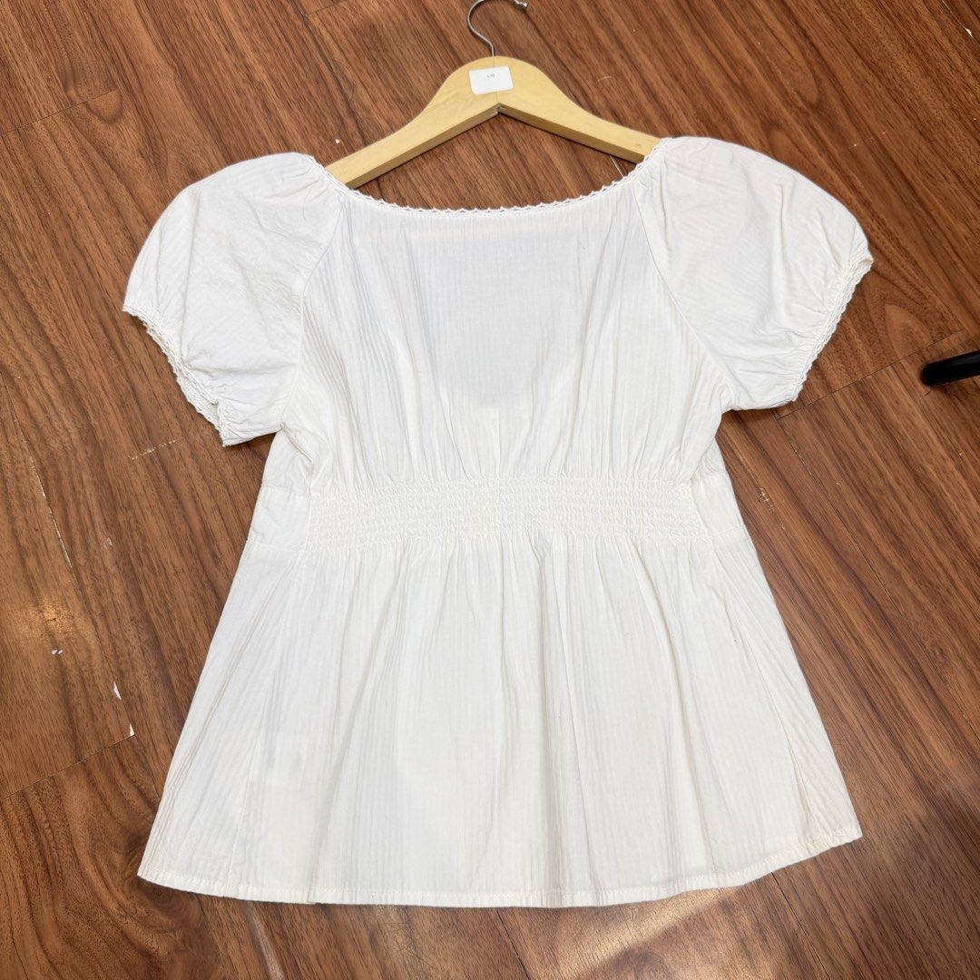 Brandy Melville White Puff Sleeve Square Neck Top (Category: Blouses) located in Manila. Submitted by angelll0123 (Listing ID 1463970843, Image 2). Description: - Can fit small-medium - White Brandy Melville top - Features puff sleeves and a square neckline - Button details down the front - Textured fabric for a unique feel - Versatile piece, great for casual styling with jeans or skirts.