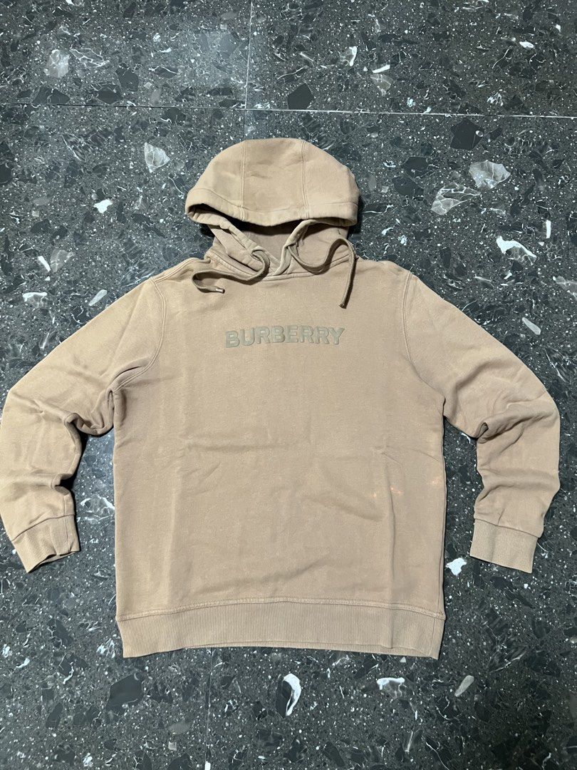 Burberry Logo Hoodie (Category: Hoodies) located in Manila. Submitted by justin_sy (Listing ID 1463983227, Image 1). Description: - Authentic Burberry hoodie - Color: Tan - Features embossed Burberry logo on chest - Material: 100% Cotton - Made in Portugal - Drawstring hood - Ideal for casual wear.
