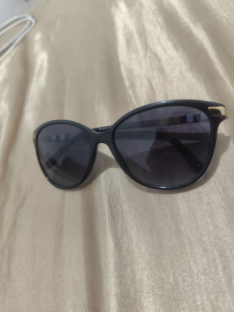 Burberry Sunglasses (Category: Sunglasses & Eyewear) located in Manila. Submitted by wildgem.7e61c6 (Listing ID 1464052247, Image 2). Description: - Authentic Burberry sunglasses - Classic shape with elegant gold accents - Signature Burberry check pattern on the arms - Dark grey gradient lenses - Minor wear on the frame near the hinge (sold as is).