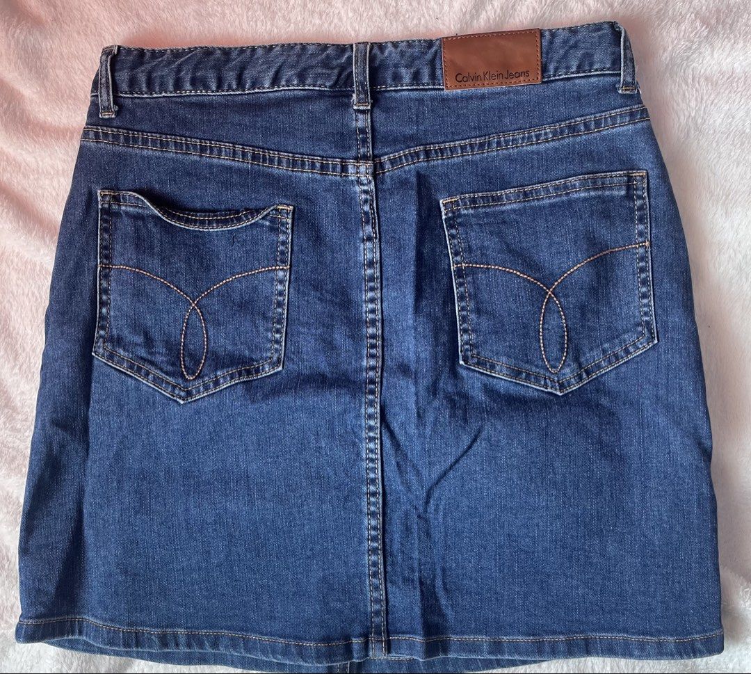 Calvin Klein Jeans Denim Skirt with Red Logo Patch (Category: Skirts) located in Cabuyao City. Submitted by jei_gspr (Listing ID 1463955006, Image 2). Description: - Classic blue denim skirt from Calvin Klein Jeans - Iconic red CK logo patch on the front - Button and zip closure - Standard five-pocket styling - Versatile piece, pairs well with t-shirts or sweaters.