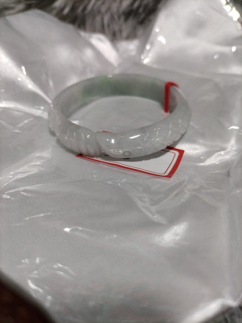 Carved Jade Bangle Bracelet Snake Design (Category: Bracelets) located in Manila. Submitted by kaicrystalsgems.ph17 (Listing ID 1463964804, Image 3). Description: - Exquisite jade bangle with a stunning translucent green hue. - Features a detailed snake carving elegantly wrapping around the bangle. - Unique and eye-catching design. - Inner diameter measures approximately 55mm. - Comes with a red string tag for authenticity or display..