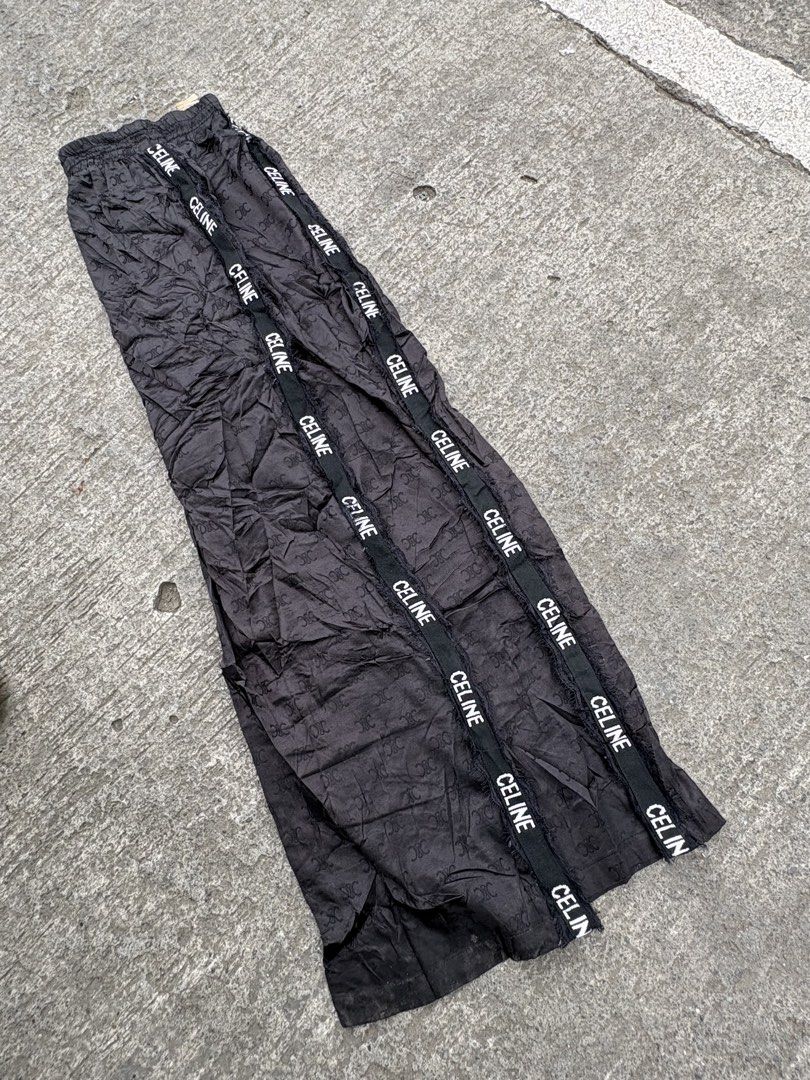 CELINE Black Monogram Track Pants Size L (Category: Other Bottoms) located in Iligan City. Submitted by seddicmoti2002 (Listing ID 1463982940, Image 2). Description: - Brand: CELINE -Wide leg - Stretchable - Color: Black - Design: All-over monogram pattern - Features: CELINE branded tape down the sides, elastic waistband - Material: 100% Nylon - Size: L (fits 165/88A).
