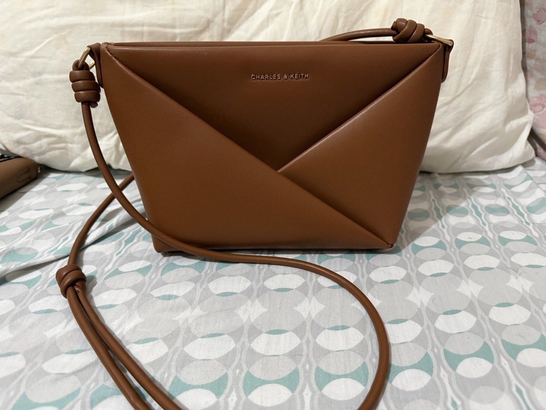 Charles & Keith Brown Leather Envelope Crossbody Bag (Category: Cross-body Bags) located in Manila. Submitted by aprilduzon (Listing ID 1464033704, Image 2). Description: - Brand: Charles & Keith - Material: Brown Leather - Design: Unique envelope style - Details: Knotted strap, gold hardware accents - Functionality: Spacious for essentials - Versatility: Ideal for day or night use.