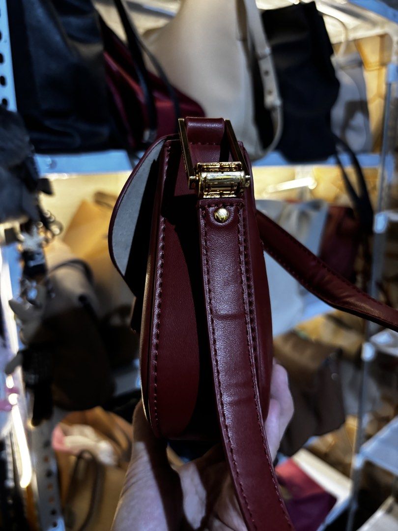 Charles & Keith Burgundy Shoulder Bag (Category: Shoulder Bags) located in Caloocan City. Submitted by _avionlineshop24 (Listing ID 1464137744, Image 3). Description: - Burgundy shoulder bag by Charles & Keith - Elegant gold hardware details - zip compartment for secure storage - Front flap closure for added style - Clean and well-maintained interior - Versatile: ideal for daily use or evening events.