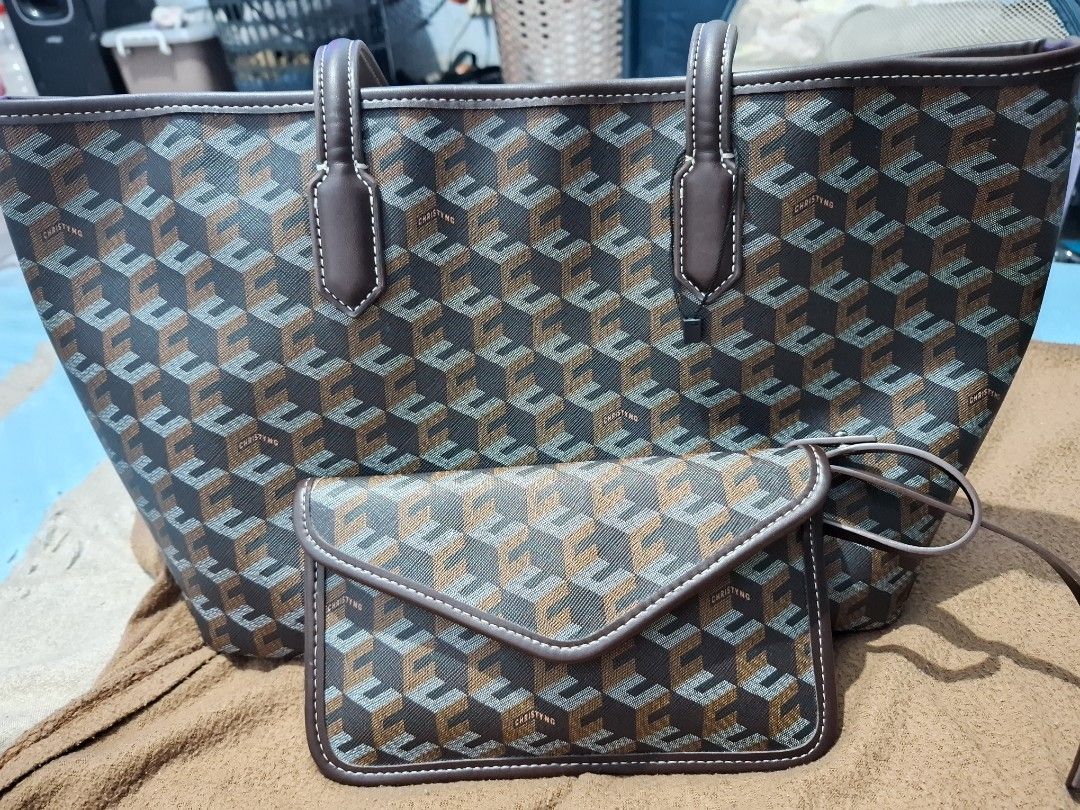 CHRISTY NG Monogram Tote Bag with Matching Pouch (Category: Tote Bags) located in Manila. Submitted by enrich_mj (Listing ID 1464046606, Image 1). Description: - Stylish monogram tote bag and matching envelope pouch set. - Classic brown and grey geometric pattern. - Accented with brown leather trim and white stitching. - Durable brown leather handles. - Pouch features a secure snap closure. - Ideal for everyday errands or travel essentials..