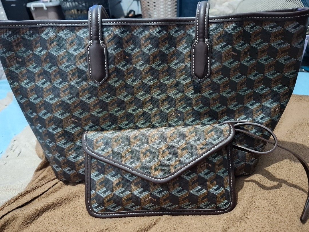 CHRISTY NG Monogram Tote Bag with Matching Pouch (Category: Tote Bags) located in Manila. Submitted by enrich_mj (Listing ID 1464046606, Image 2). Description: - Stylish monogram tote bag and matching envelope pouch set. - Classic brown and grey geometric pattern. - Accented with brown leather trim and white stitching. - Durable brown leather handles. - Pouch features a secure snap closure. - Ideal for everyday errands or travel essentials..
