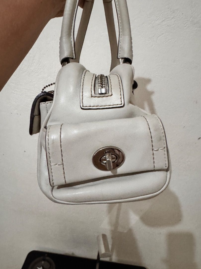 Coach Leather Handbag Off-White (Category: Luxury Bags & Wallets) located in Dumaguete. Submitted by luxxe_babe (Listing ID 1464132761, Image 2). Description: PRICE IS STILL NEGOTIABLE - Authentic Coach leather handbag - Color: Off-white - Features a front flap with buckle closure - Equipped with top handles for easy carrying - Shows some signs of wear on leather and hardware, consistent with use - Interior is clean and well-maintained - A classi