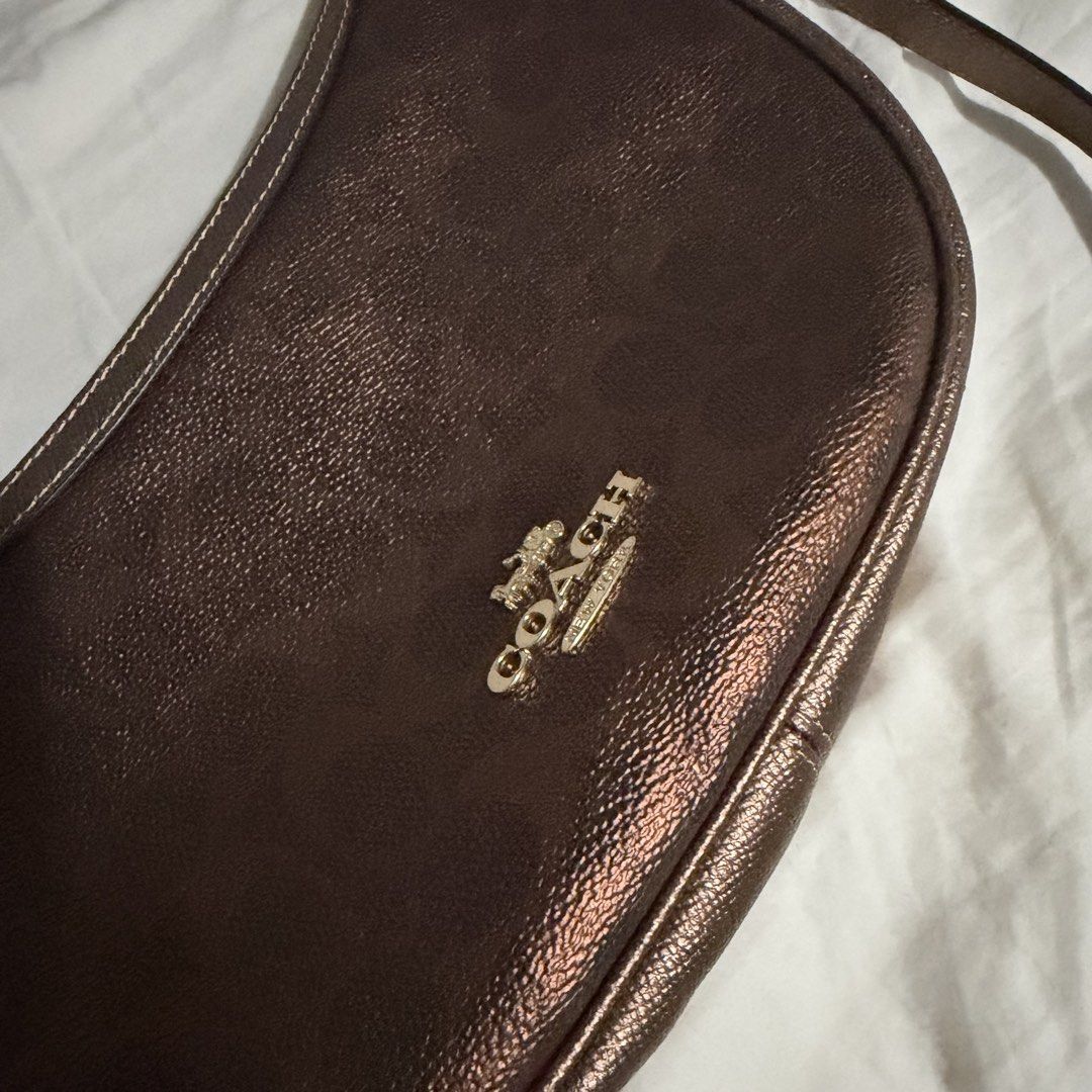 Coach Metallic Brown Copper Aria Half Moon Shoulder Bag (Category: Shoulder Bags) located in Caloocan City. Submitted by dearvals (Listing ID 1463966899, Image 3). Description: - Coach crescent shoulder bag - Metallic brown with subtle texture - Gold hardware and front Coach logo - Adjustable strap - Brand new with original tags attached - Versatile for everyday or evening wear.