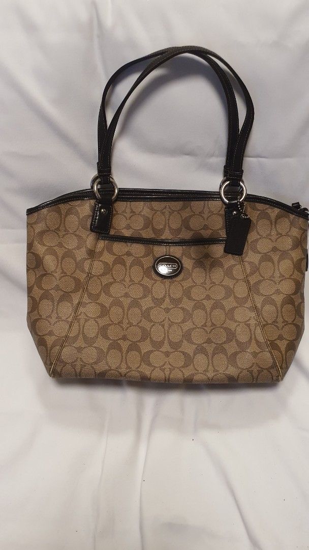 Coach Monogram Canvas Leather Trim Tote Bag (Category: Luxury Bags & Wallets) located in Pasig City. Submitted by angel025 (Listing ID 1464124717, Image 1). Description: - Classic Coach monogram tote - Color: Brown canvas with black leather trim and handles - Spacious interior for essentials - Includes an inside zippered pocket - Silver hardware details - Ideal for everyday use - like new.