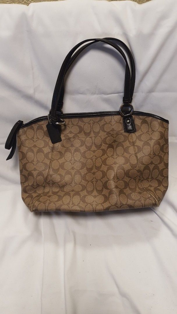 Coach Monogram Canvas Leather Trim Tote Bag (Category: Luxury Bags & Wallets) located in Pasig City. Submitted by angel025 (Listing ID 1464124717, Image 2). Description: - Classic Coach monogram tote - Color: Brown canvas with black leather trim and handles - Spacious interior for essentials - Includes an inside zippered pocket - Silver hardware details - Ideal for everyday use - like new.