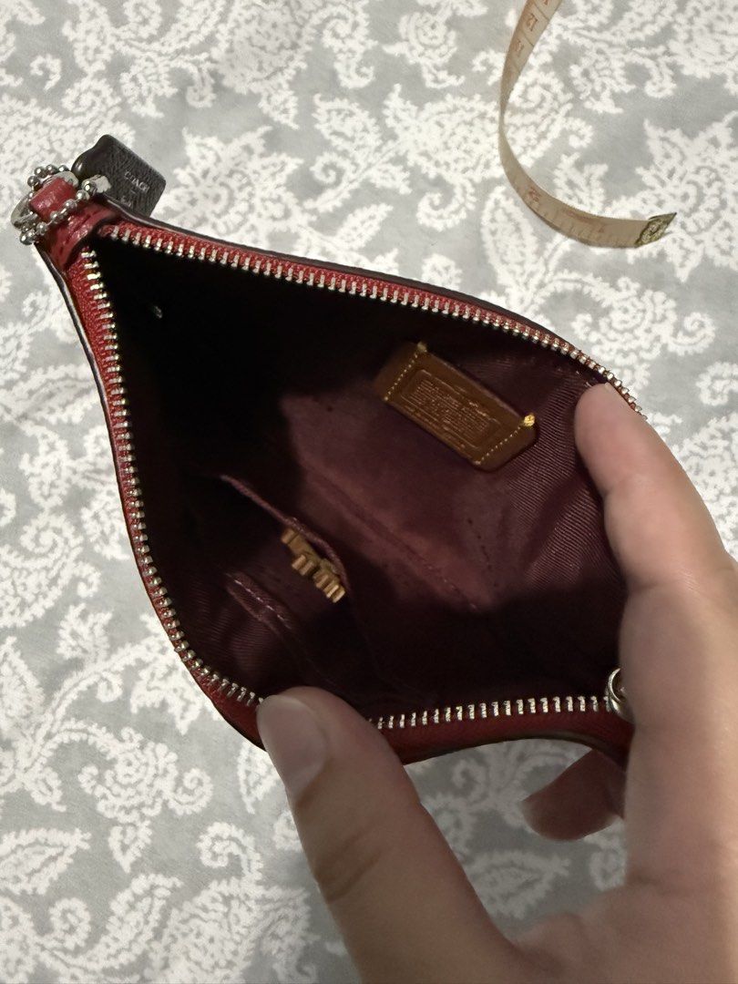 Coach Red Leather Pouch with Emblem (Category: Purses & Pouches) located in Quezon City. Submitted by akestrella (Listing ID 1464080971, Image 3). Description: - Authentic Coach red leather pouch - Features a cool emblem on the front - Secure zipper closure - Interior has a small Coach tag - Ideal for organizing your essentials - Approximate dimensions: 8 inches wide x 4 inches tall.