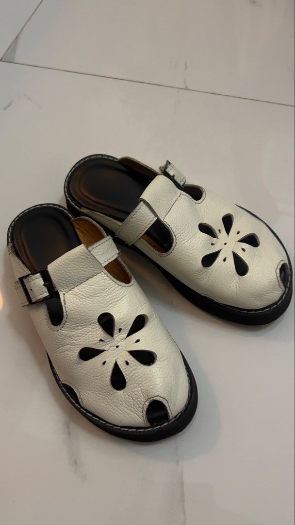 Comfort Club Malaya Mules (Category: Flats & Sandals) located in Marikina City. Submitted by clutters.of.a (Listing ID 1464127214, Image 1). Description: - White leather mules - Adorable flower cut-out design - Open-toe style - Adjustable strap with buckle closure - Easy slip-on for convenience - Comfortable for everyday wear - Black sole with white stitching detail.