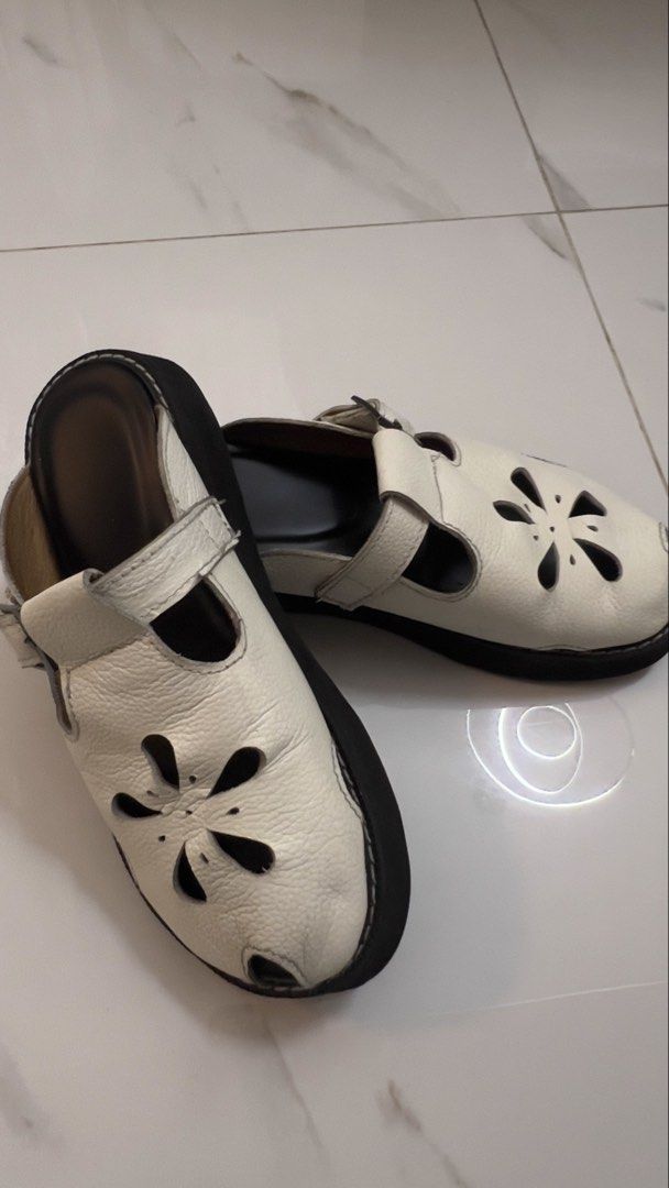 Comfort Club Malaya Mules (Category: Flats & Sandals) located in Marikina City. Submitted by clutters.of.a (Listing ID 1464127214, Image 3). Description: - White leather mules - Adorable flower cut-out design - Open-toe style - Adjustable strap with buckle closure - Easy slip-on for convenience - Comfortable for everyday wear - Black sole with white stitching detail.