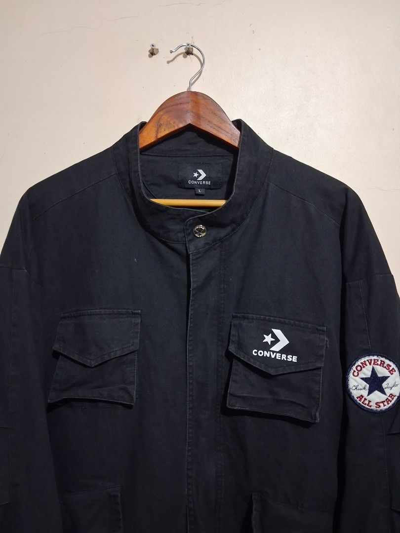 Converse Black Utility Jacket with Patches (Category: Coats, Jackets and Outerwear) located in Manila. Submitted by randf_selections (Listing ID 1464124127, Image 3). Description: Black Converse jacket. Has multiple utility pockets on the front. Features a Converse patch on the left sleeve and a circular Converse All Star patch on the upper right sleeve. Button closure. Size L..