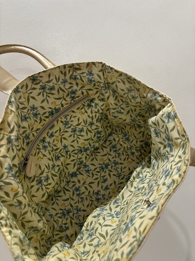 Cream & Gold Patterned Tote Bag with Floral Lining (Category: Tote Bags) located in Bulacan. Submitted by janeeeeelleeeee (Listing ID 1464121749, Image 3). Description: - Cream colored tote bag - Repeating gold starburst pattern - Tan leather handles and trim - Interior with floral lining - One zippered pocket inside - Snap closure at the top - Ideal for everyday use or weekend trips.