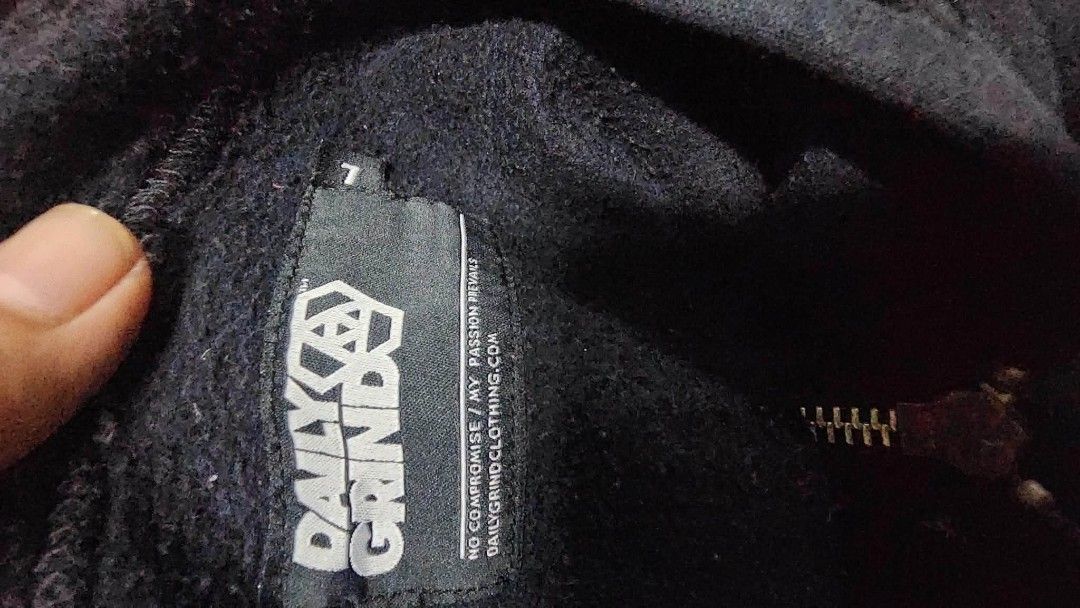 Daily Grind Zip-Up Hoodie (Category: Coats, Jackets and Outerwear) located in Calamba. Submitted by ysabellascloset17 (Listing ID 1463956763, Image 3). Description: - Black zip-up hoodie from Daily Grind - Features signature logo graphic on the front - Includes a patch on the left sleeve - Made from comfortable material - Perfect for everyday casual wear.