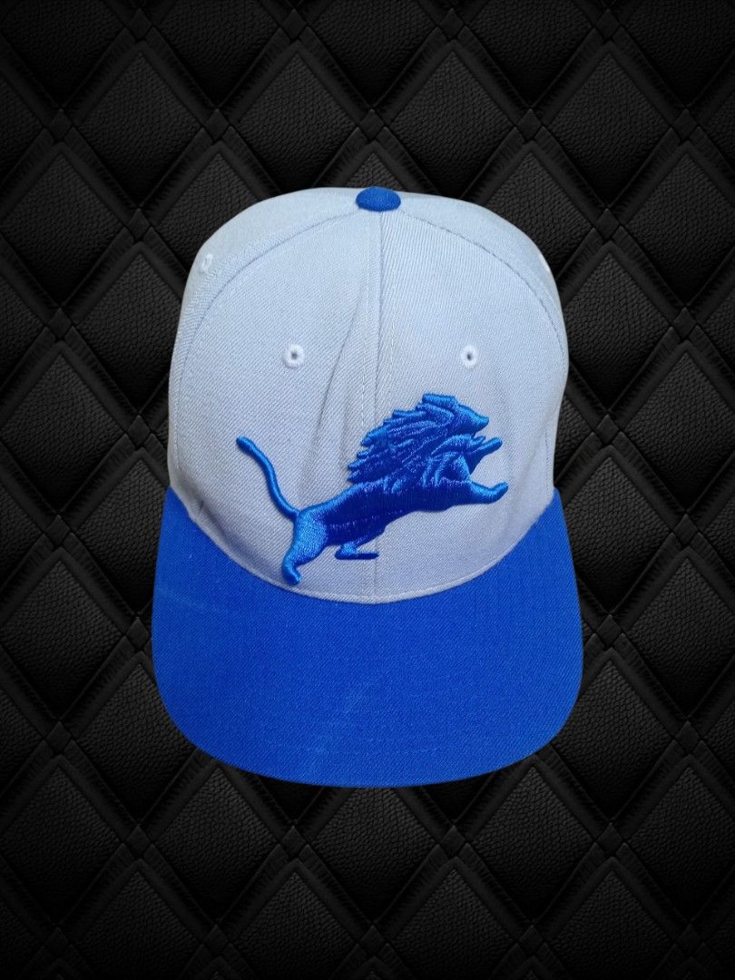 Detroit Lions Mitchell and Ness Snapback Cap (Category: Caps & Hats) located in Aguinaldo. Submitted by ukayandthrift (Listing ID 1463941317, Image 1). Description: - Detroit Lions snapback cap - Features Puma logo and roaring lion emblem - Light blue crown with royal blue brim - Adjustable strap for a comfortable fit - Ideal for game days or casual wear.