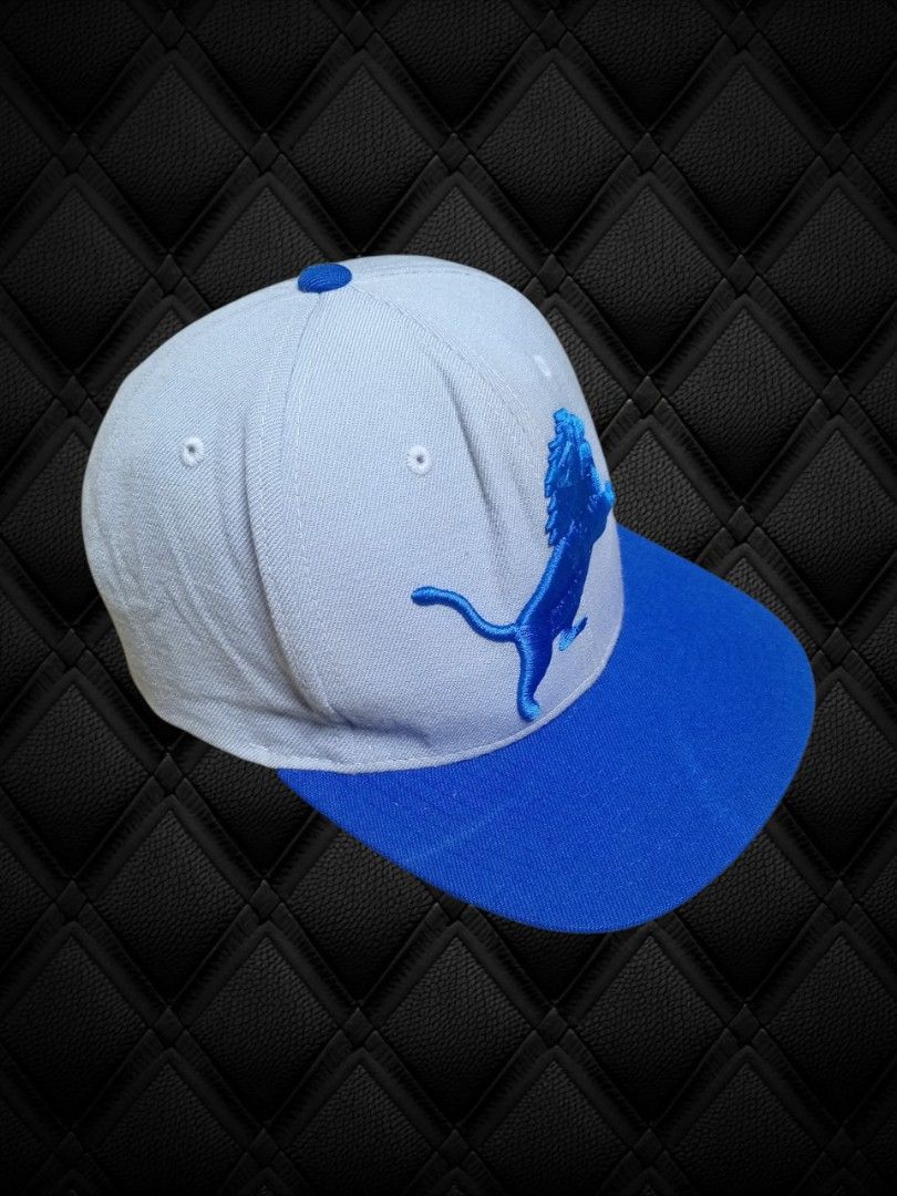 Detroit Lions Mitchell and Ness Snapback Cap (Category: Caps & Hats) located in Aguinaldo. Submitted by ukayandthrift (Listing ID 1463941317, Image 2). Description: - Detroit Lions snapback cap - Features Puma logo and roaring lion emblem - Light blue crown with royal blue brim - Adjustable strap for a comfortable fit - Ideal for game days or casual wear.