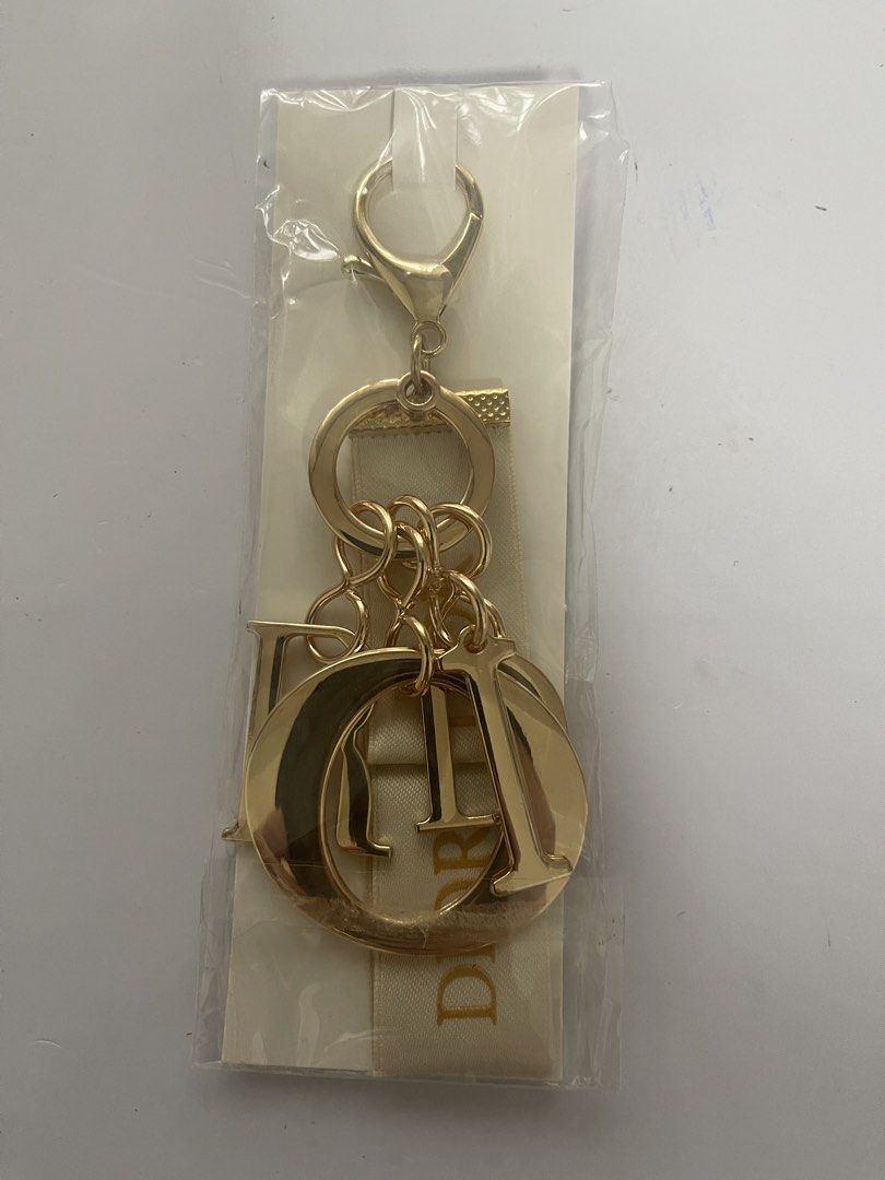 Dior Gold Charm Keychain with Ribbon (Category: Luxury Accessories) located in Quezon City. Submitted by kingcurator (Listing ID 1463990494, Image 1). Description: - Authentic Dior charm keychain - Features iconic Dior logo letters - Elegant ribbon detail - Shiny gold finish - Versatile for bags or keys - Includes original packaging.
