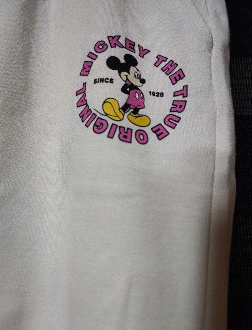 Disney White Mickey Mouse Sweatpants (Category: Other Bottoms) located in Pasig City. Submitted by abogadosupremo (Listing ID 1464078427, Image 2). Description: White sweatpants featuring a Mickey Mouse design. - The front has a Mickey Mouse graphic with the text "Mickey The True Original Since 1928". The back has a small pocket and the text "Original Mickey" with a Mickey Mouse graphic on the other leg. -It has a drawstring waist and elastic cuf