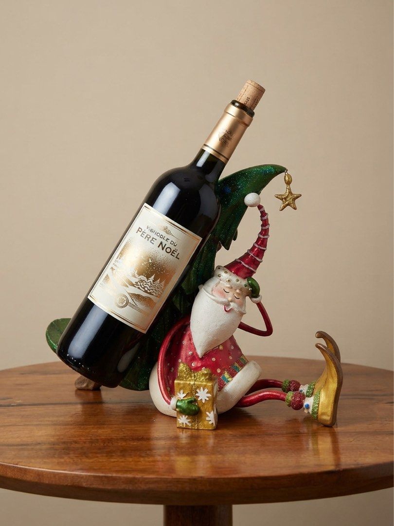 Drunk Santa Claus single-bottled wine holder (Category: Other Home Decor) located in Nagcarlan. Submitted by snccollection (Listing ID 1463973780, Image 3). Description: Christmas Decorative Figurine. Handcrafted polyresin/resin holiday figurine or table accessory. Features a seated, whimsical Santa Claus holding a wrapped gift, leaning back while propping up a decorated green Christmas tree that doubles as a cradle for a wine bottle. RFS: Declut