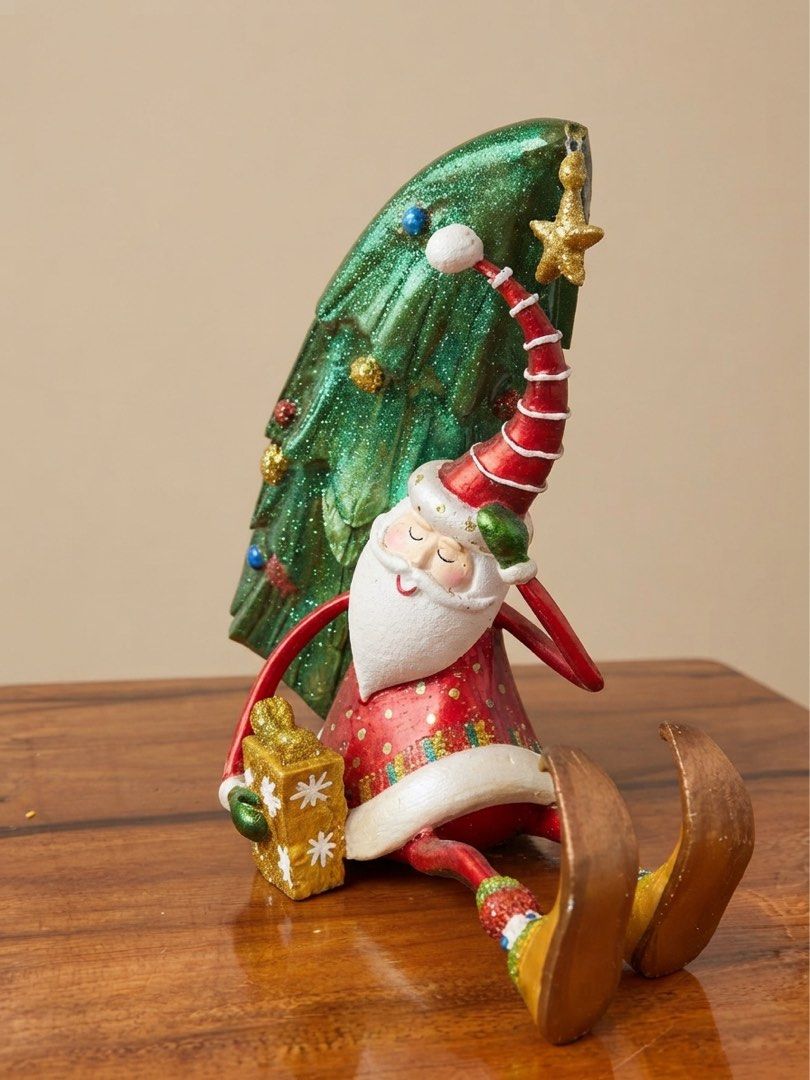 Drunk Santa Claus single-bottled wine holder (Category: Other Home Decor) located in Nagcarlan. Submitted by snccollection (Listing ID 1463973780, Image 2). Description: Christmas Decorative Figurine. Handcrafted polyresin/resin holiday figurine or table accessory. Features a seated, whimsical Santa Claus holding a wrapped gift, leaning back while propping up a decorated green Christmas tree that doubles as a cradle for a wine bottle. RFS: Declut