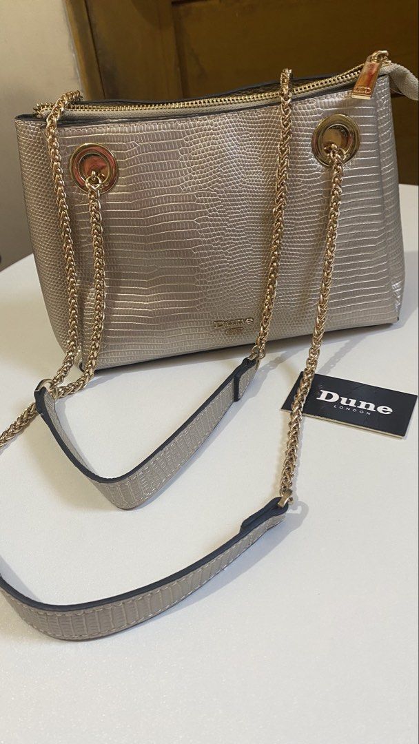 DUNE LONDON BAG CHAIN HANDLE (Category: Shoulder Bags) located in Manila. Submitted by itsaerabella (Listing ID 1463946763, Image 1). Description: PRE-OWNED Dune London Bag Gilded Metallic Chain Strap (Non-tarnish) Bought it for $130 ( 7k plus pesos) Slightly used, looks new pa tlga. What you see is what you get. This bag can be paired with on-trend outfits for a stylish look. minimal issue: yung sa front, my nadikit lang na pandikit, pero hnd nm