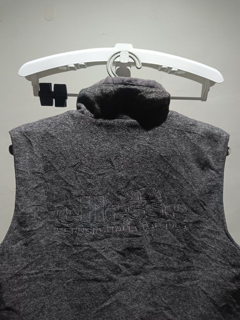 Ellesse Fleece Vest reversible (Category: Vests) located in Santiago. Submitted by PjThrift (Listing ID 1463959215, Image 2). Description: - Dark grey fleece vest from Ellesse - Zip-up front with mock neck - Two convenient front pockets - Embroidered Ellesse logo on chest - Large embroidered 'Perugia Italia Est. 1959' logo on back - Ideal for layering in cooler weather.