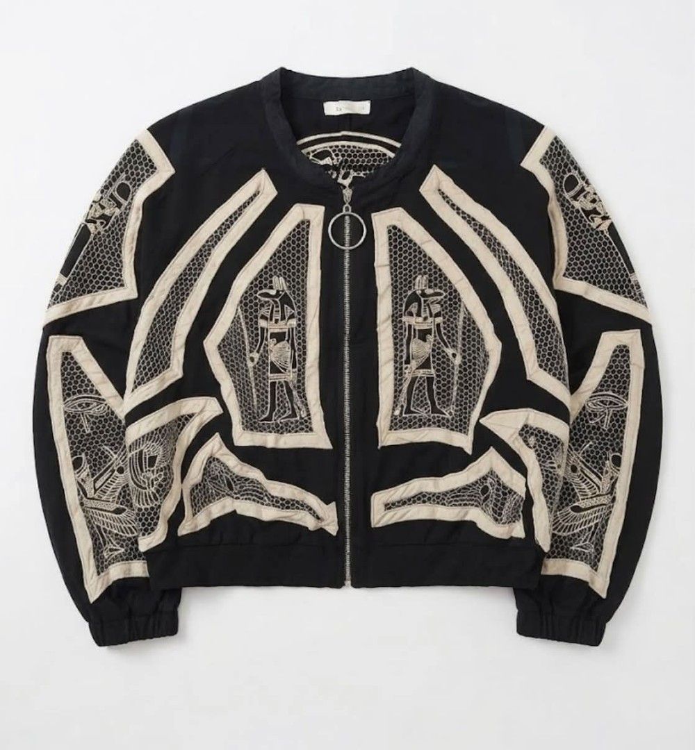 Embroidered silk jacket (Category: Longsleeves) located in Donsol. Submitted by saksthriftavenuebyluckymaria8 (Listing ID 1464078419, Image 1). Description: FULLY EMBROIDERED SILK BOMBER JACKET SZ F chest 29in length 20in The is a black and beige zip-up bomber jacket featuring silk panels and intricate Egyptian-inspired deity and symbol embroideries . signs of usage on the trims.