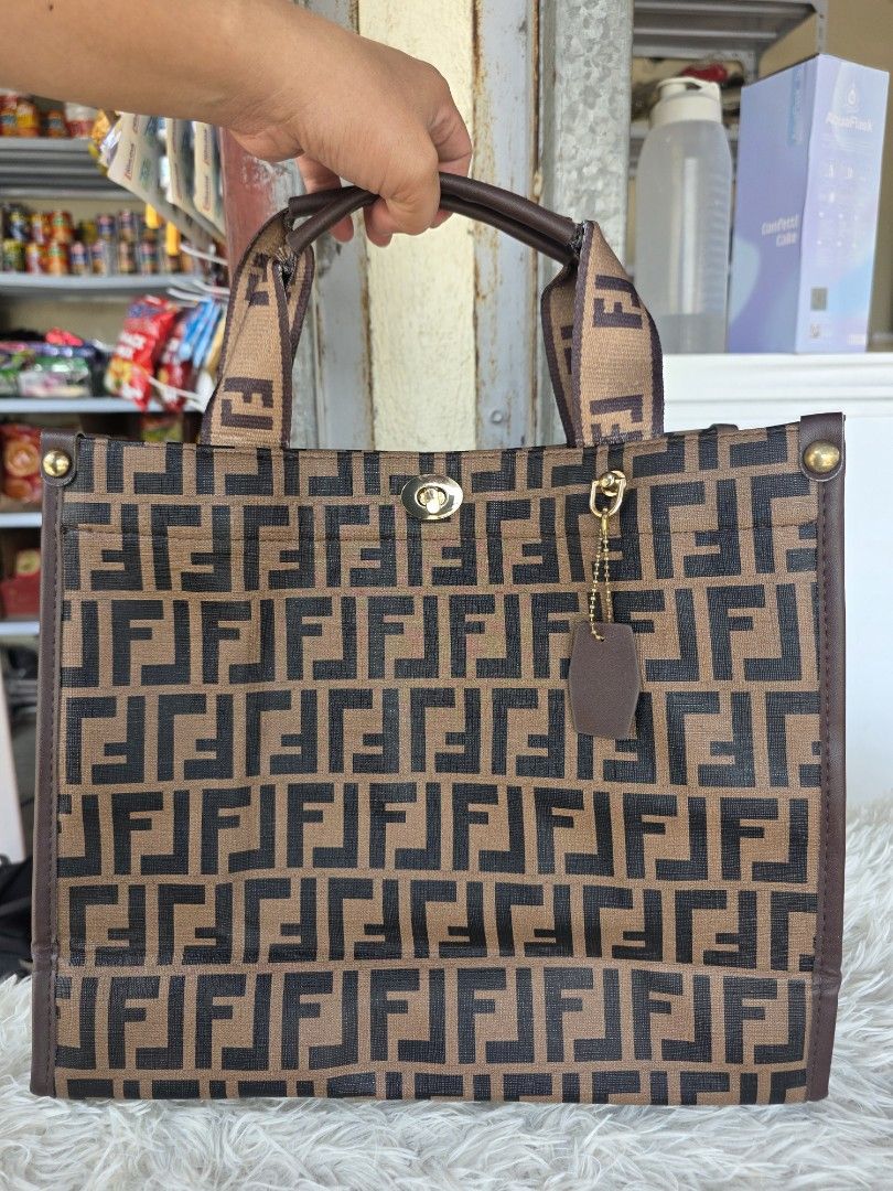 Fendi Monogram Tote Bag (Category: Tote Bags) located in Agoncillo. Submitted by vinsoy07 (Listing ID 1463992866, Image 1). Description: - Classic Fendi monogram tote bag - Iconic brown and black FF pattern - Genuine leather trim and handles - Gold hardware details - Purple interior lining - Interior zippered pocket - Ideal for everyday use or travel.