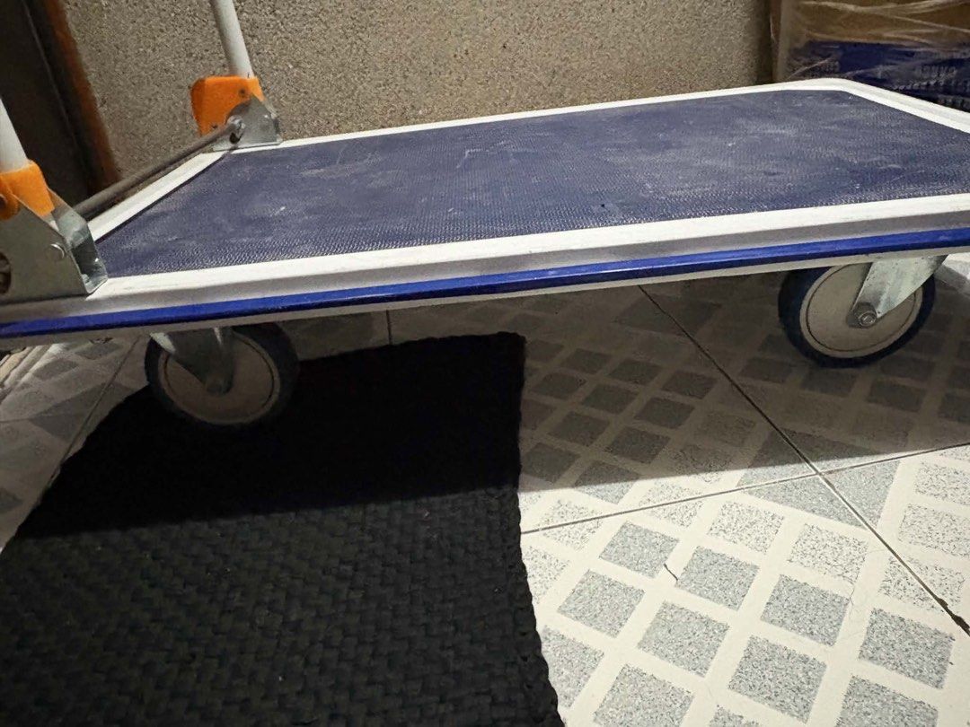 Folding Trolley Cart with Handle (Category: Strollers) located in Mandaluyong City. Submitted by janleevee (Listing ID 1463957622, Image 2). Description: - Heavy duty folding trolley cart - Blue platform with white trim - Sturdy handle for easy maneuvering - Rolls smoothly on four wheels - Ideal for moving boxes and heavy items - Folds flat for convenient storage - Great for home or office use.