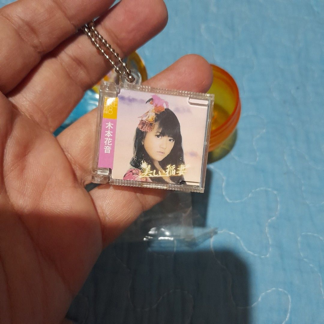 Gachapon Capsule Toy with Mini CD Keychain (Category: Designer & Blind Box Toys) located in Bocaue. Submitted by marajapansurplus (Listing ID 1464018896, Image 3). Description: - Authentic Gachapon capsule toy - Includes a mini CD with Japanese text - Features a keychain with a girl's picture - Original orange and blue capsule packaging - Sold as is.